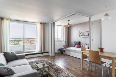 Idée de décoration pour une salle de séjour design de taille moyenne et ouverte avec un mur blanc, un sol en bois brun et un sol marron.