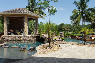 Large trendy backyard stone and custom-shaped natural hot tub photo in Miami