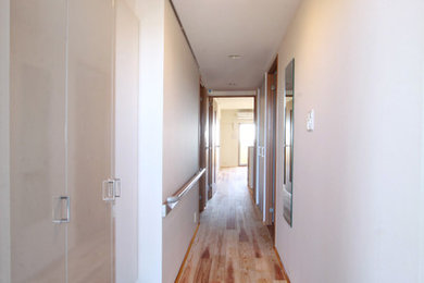 Design ideas for a modern foyer with white walls, medium hardwood floors and multi-coloured floor.