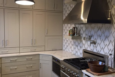 Mid-sized transitional u-shaped dark wood floor enclosed kitchen photo in New York with a farmhouse sink, shaker cabinets, gray cabinets, quartzite countertops, multicolored backsplash, porcelain backsplash, stainless steel appliances and no island