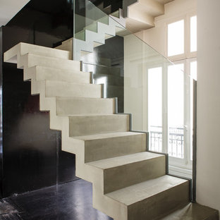 Photo of a medium sized contemporary concrete u-shaped staircase in Paris with concrete risers.