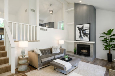 Trendy laminate floor and multicolored floor living room photo in Kansas City with gray walls, a standard fireplace and a tile fireplace