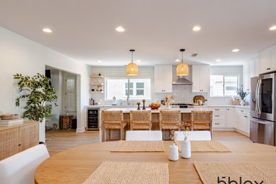 Kitchen - mid-sized transitional l-shaped medium tone wood floor and beige floor kitchen idea in Los Angeles with an undermount sink, shaker cabinets, white cabinets, ceramic backsplash, stainless steel appliances, an island and multicolored countertops