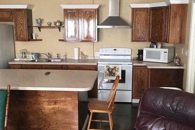 Open concept kitchen - mid-sized traditional l-shaped open concept kitchen idea in New Orleans with a double-bowl sink, raised-panel cabinets, medium tone wood cabinets, white appliances and an island