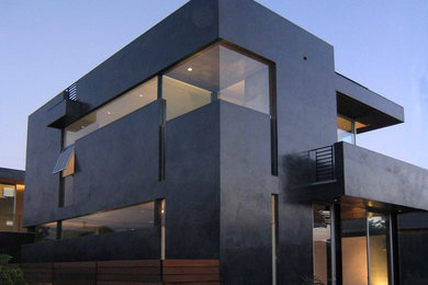 Inspiration for a contemporary black two-story exterior home remodel in Los Angeles with a mixed material roof