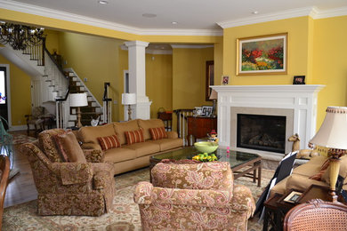 Example of a mid-sized country formal and open concept medium tone wood floor living room design in Other with yellow walls, a standard fireplace and a wood fireplace surround