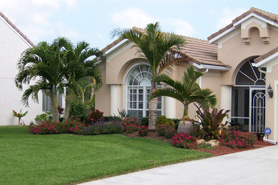 Photo of a mid-sized tropical full sun front yard concrete paver driveway in Miami for summer.