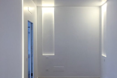 Esempio di un soggiorno moderno di medie dimensioni e chiuso con pareti bianche e pavimento in laminato