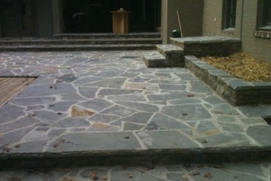 This is an example of a large backyard patio in Birmingham with natural stone pavers.