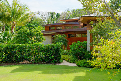 Large contemporary brown two-story concrete house exterior idea in Other with a hip roof and a shingle roof