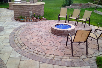 Photo of a large transitional backyard patio in Chicago with a fire feature and brick pavers.