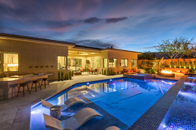 Contemporary Backyard Pool with Tiled Water Feature, Rim Flow Spa, & Fire Pit