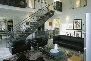 Example of a large minimalist formal and open concept concrete floor living room design in Los Angeles with white walls, a standard fireplace, a metal fireplace and a media wall