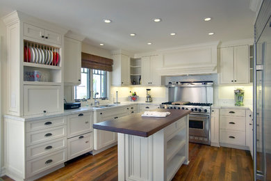 Large traditional u-shaped eat-in kitchen in San Diego with a drop-in sink, shaker cabinets, white cabinets, marble benchtops, white splashback, marble splashback, stainless steel appliances, medium hardwood floors, with island, brown floor and white benchtop.