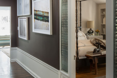 Mid-sized elegant medium tone wood floor hallway photo in Los Angeles with brown walls