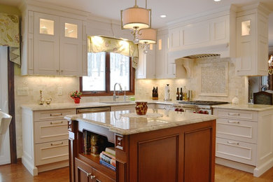 Mid-sized elegant u-shaped medium tone wood floor and brown floor eat-in kitchen photo in New York with an undermount sink, recessed-panel cabinets, white cabinets, marble countertops, beige backsplash, porcelain backsplash, paneled appliances, an island and beige countertops