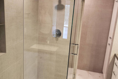 Example of a corner shower design in San Diego with a hinged shower door and a floating vanity