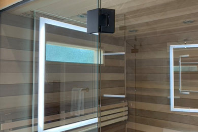 Photo of a large modern ensuite bathroom in Dallas with flat-panel cabinets, dark wood cabinets, a corner shower, a one-piece toilet, black tiles, porcelain tiles, white walls, porcelain flooring, a submerged sink, engineered stone worktops, black floors, a hinged door, white worktops, double sinks and a floating vanity unit.