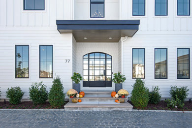 Modern white two-story board and batten house exterior idea in Other