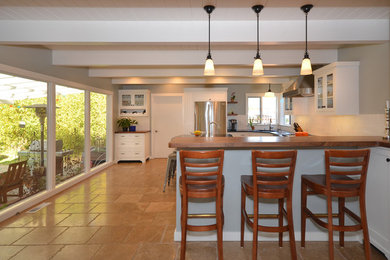 Example of a mid-sized mid-century modern u-shaped ceramic tile seated home bar design in San Francisco with shaker cabinets, white cabinets, wood countertops, white backsplash and subway tile backsplash