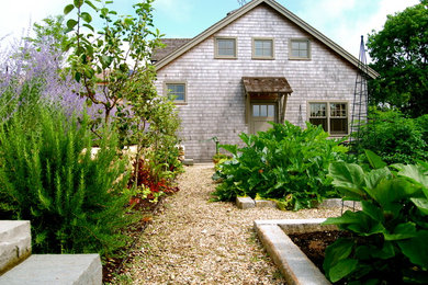 This is an example of a mid-sized country backyard full sun formal garden for summer in Boston with a vegetable garden and gravel.