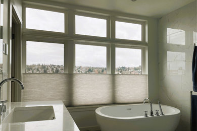 シアトルにあるお手頃価格の広いトランジショナルスタイルのおしゃれなマスターバスルーム (置き型浴槽、白いタイル、アンダーカウンター洗面器、洗面台2つ) の写真