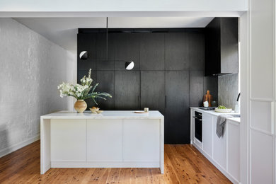 Foto på ett mellanstort minimalistiskt grå kök, med en undermonterad diskho, skåp i shakerstil, skåp i mörkt trä, bänkskiva i kvarts, grått stänkskydd, stänkskydd i keramik, svarta vitvaror, ljust trägolv, en köksö och brunt golv