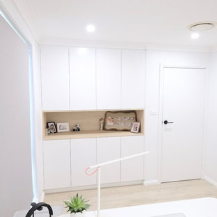 Inspiration for a medium sized modern study in Sydney with white walls, laminate floors, a freestanding desk and beige floors.