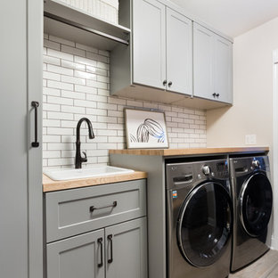 Design ideas for a medium sized modern utility room in Chicago with a single-bowl sink, shaker cabinets, grey cabinets, wood worktops, beige walls, ceramic flooring, a side by side washer and dryer and beige worktops.