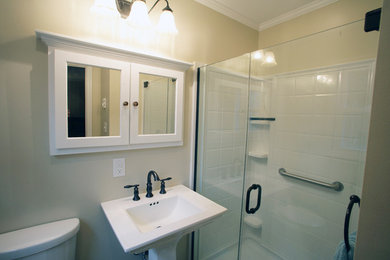 Transitional 3/4 white tile and porcelain tile alcove shower photo in New York with a one-piece toilet, beige walls, a pedestal sink and solid surface countertops