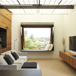 Inspiration for a modern family room in San Francisco with beige walls and a wall-mounted tv.