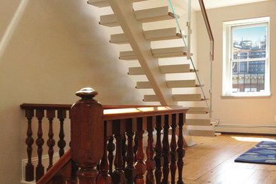 Photo of a large transitional wood straight staircase in Boston with painted wood risers.