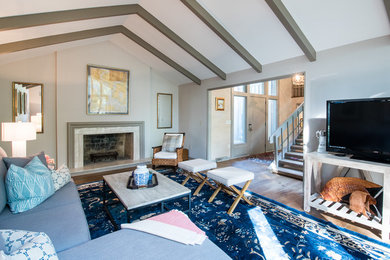 Inspiration for a mid-sized timeless enclosed medium tone wood floor family room remodel in Charleston with gray walls, a standard fireplace, a stone fireplace and a tv stand