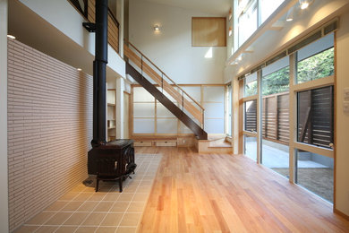 Inspiration for a mid-sized contemporary enclosed medium tone wood floor and brown floor living room remodel in Other with white walls, a wood stove, a tile fireplace and a tv stand