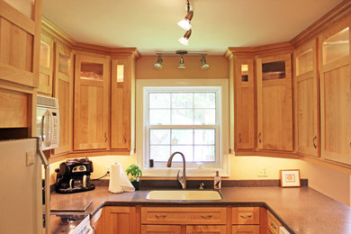 Example of a mid-sized classic u-shaped enclosed kitchen design in Other with an undermount sink, shaker cabinets, light wood cabinets, quartz countertops, white appliances, no island and gray countertops