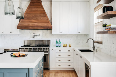 Inspiration for a mid-sized transitional u-shaped separate kitchen in San Francisco with an undermount sink, shaker cabinets, white cabinets, quartz benchtops, white splashback, marble splashback, stainless steel appliances, light hardwood floors, with island, beige floor and white benchtop.