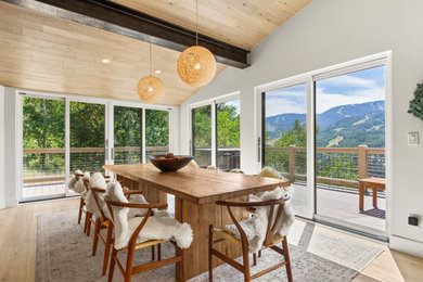 Mid-sized danish light wood floor and exposed beam kitchen/dining room combo photo in Denver with white walls