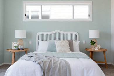 This is an example of a beach style bedroom in Brisbane with white walls, carpet and grey floor.