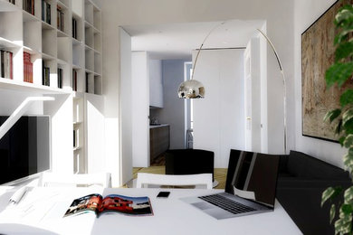 Idee per uno studio design di medie dimensioni con libreria, pareti bianche, parquet chiaro, scrivania autoportante e pavimento marrone