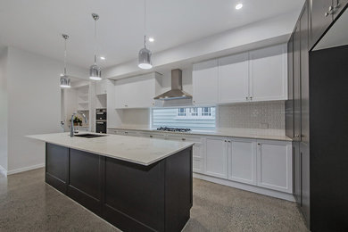 Inspiration for a mid-sized transitional galley eat-in kitchen in Brisbane with an undermount sink, beaded inset cabinets, white cabinets, marble benchtops, white splashback, ceramic splashback, concrete floors, with island, grey floor and white benchtop.