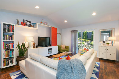 Family room - mid-sized transitional open concept medium tone wood floor family room idea in Seattle with white walls and a tv stand