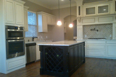 Inspiration for a transitional l-shaped eat-in kitchen remodel in Dallas with an undermount sink, raised-panel cabinets, white cabinets, granite countertops, beige backsplash, subway tile backsplash and stainless steel appliances