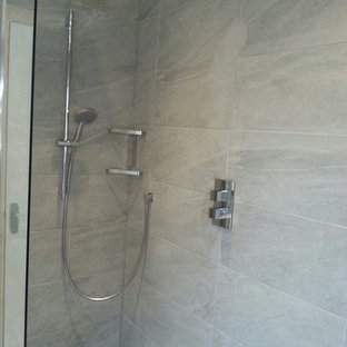 Cette photo montre une salle de bain tendance de taille moyenne pour enfant avec un lavabo suspendu, des portes de placard grises, un plan de toilette en stratifié, une douche ouverte, un WC suspendu, un carrelage gris, des carreaux de porcelaine, un mur gris et un sol en carrelage de porcelaine.