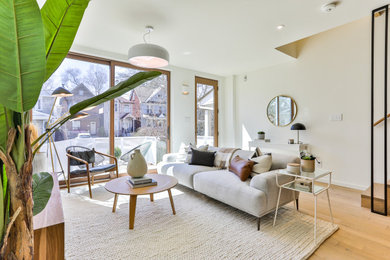 Inspiration for a small modern open concept light wood floor living room remodel in Toronto with white walls