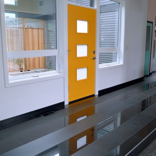 Inspiration för en eklektisk ingång och ytterdörr, med vita väggar, klinkergolv i porslin, en gul dörr och svart golv