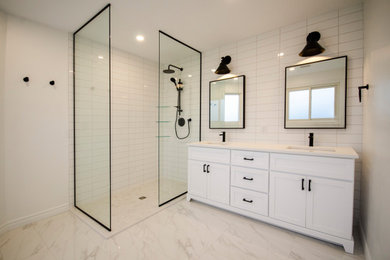 This is an example of a mid-sized modern master bathroom in Toronto with white cabinets, an open shower, white tile, porcelain tile, engineered quartz benchtops, white benchtops, a double vanity and a freestanding vanity.