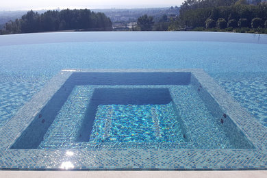 Large trendy backyard tile and rectangular infinity hot tub photo in Los Angeles