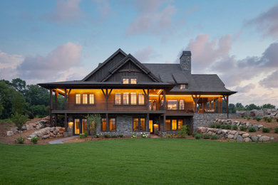 Inspiration for a huge rustic brown two-story wood exterior home remodel in Minneapolis with a shingle roof and a black roof