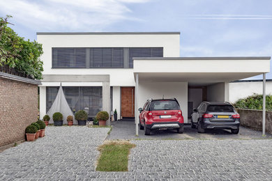 Mittelgroßes, Zweistöckiges Modernes Haus mit Putzfassade, weißer Fassadenfarbe und Flachdach in Sonstige
