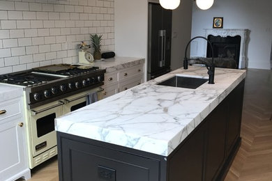 Open concept kitchen - mid-sized victorian single-wall light wood floor and brown floor open concept kitchen idea in Toronto with an undermount sink, shaker cabinets, white cabinets, marble countertops, white backsplash, subway tile backsplash, colored appliances, an island and gray countertops